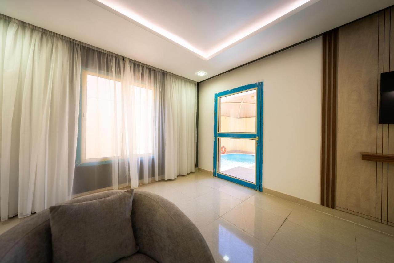 Mirada Gold Jizan - Resort & Private Pools Luaran gambar The photo shows a modern interior space that appears to be a room in a home or a building. There is a large window with sheer curtains letting in natural light, which contributes to a bright and airy atmosphere. On one side of the room, there is a sl